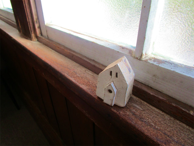 木枠の窓にさりげなく置かれた陶器の家